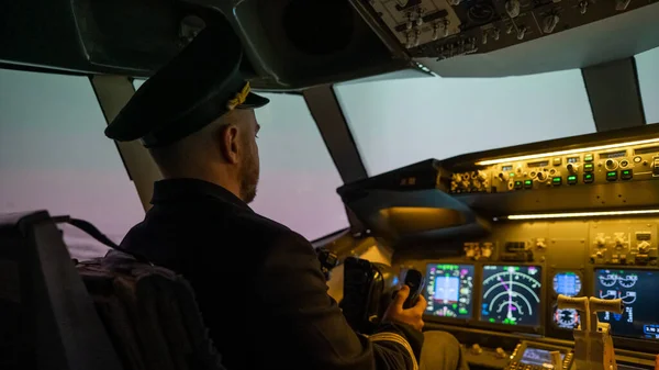 A man is studying to be a pilot in an aircraft simulator