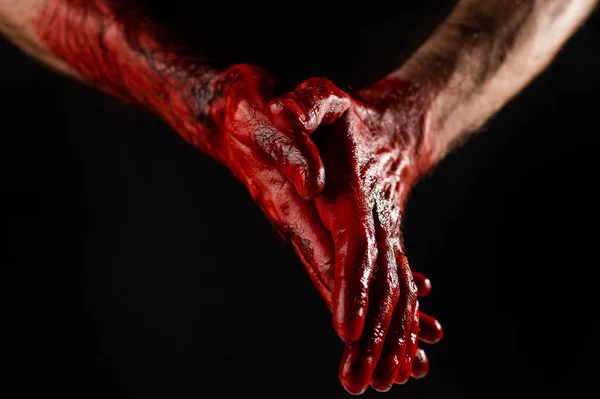 男性の手のひらは黒の背景に血で染色されています — ストック写真