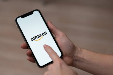 3 Aralık 2022 Almaty Kazakistan: Ekranda Amazon logosu olan yüzsüz kadın akıllı telefon tutuyor