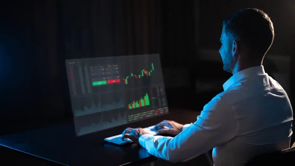 Caucasian Man Sits Dark Front Virtual Screen Stock Exchange Charts — Stok fotoğraf