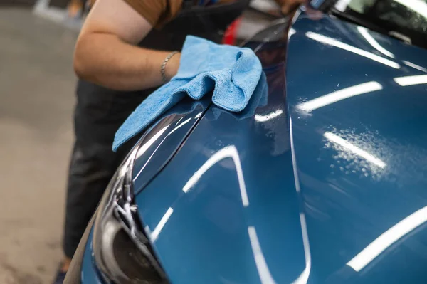 汽车维修的主人在涂了保护膜后用餐巾纸擦拭汽车 — 图库照片