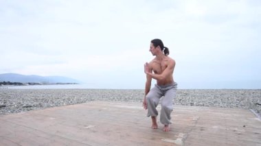 Beyaz adam dışarıda dövüş sanatları yapıyor. denge ve meditasyon