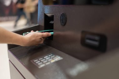 ATM 'de akıllı telefon kullanan bir kadın. NFC çevrimiçi bankacılık kavramı
