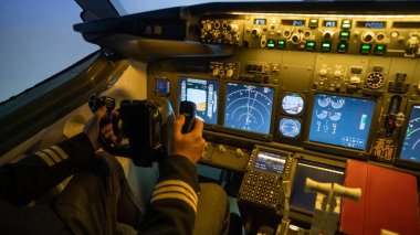 Bir adam uçuş simülatöründe pilot olmak için çalışıyor. Erkek ellerinin yakın plan bir hava aracında gezinmesi.