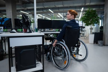 Caucasian woman in wheelchair at work desk