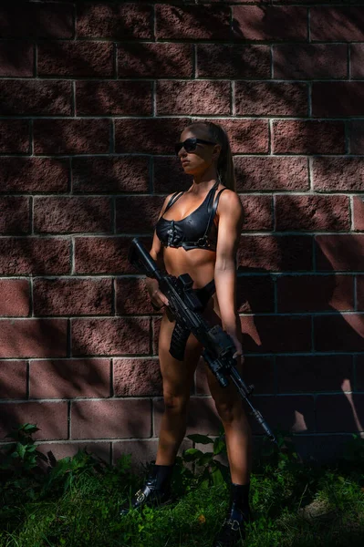 Kaukasisk Kvinna Bikini Håller Ett Maskingevär Mot Tegelvägg — Stockfoto
