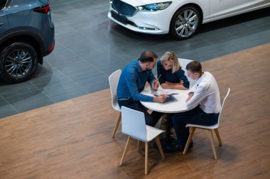 Kafkasyalı mutlu çift bir araba kuaförü satın almak için sözleşme imzaladı.