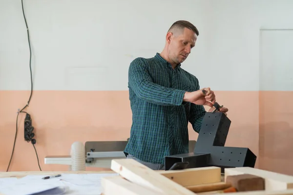 stock image Carpenter measures a metal connector for wooden parts