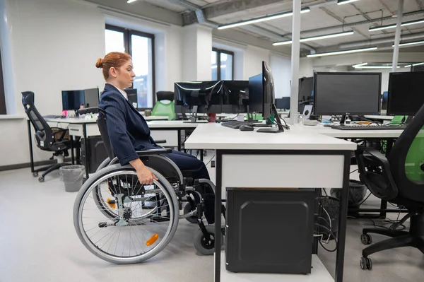 Caucasian woman in wheelchair at work desk