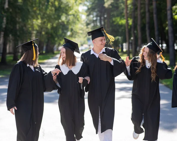 Fila Jovens Felizes Vestidos Graduação Livre Alunos Estão Caminhando Parque — Fotografia de Stock