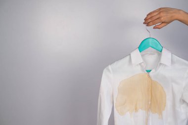 Beyaz arka planda kahve lekesi olan kadın ofis beyaz gömleği.