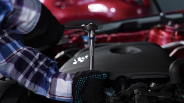 女性の自動車整備士は車の火花プラグを交換するナットを外します — ストック動画