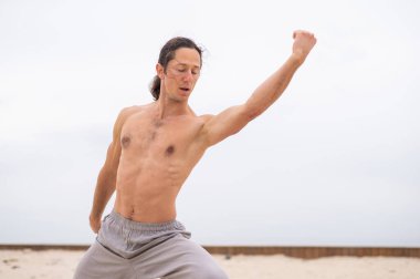 Beyaz adam dışarıda dövüş sanatları yapıyor. denge ve meditasyon
