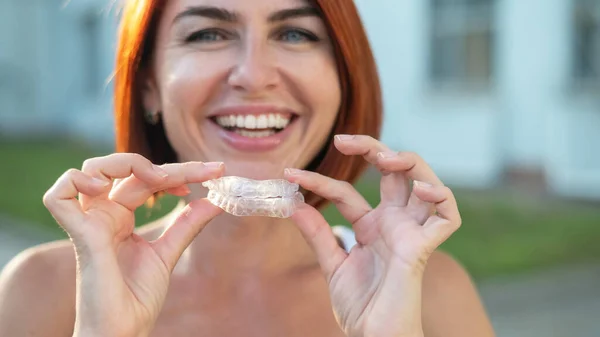 Red Haired Caucasian Woman Holding Transparent Mouthguards Bite Correction Outdoors — Stock Photo, Image