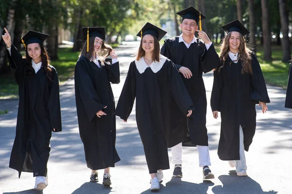 Μια Σειρά Από Χαρούμενους Νέους Φορέματα Αποφοίτησης Έξω Μαθητές Περπατούν — Φωτογραφία Αρχείου