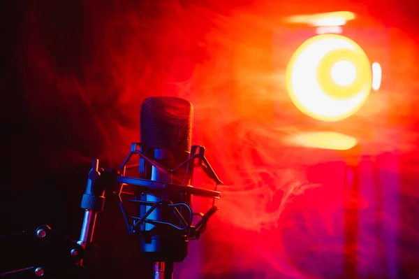 Professional microphone in red blue smoke on a black background