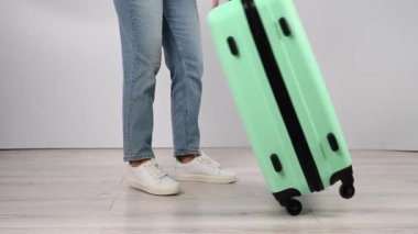 Kadın valizini yere koyar ve yukarıdan atlar. Kız bavulu test ediyor.