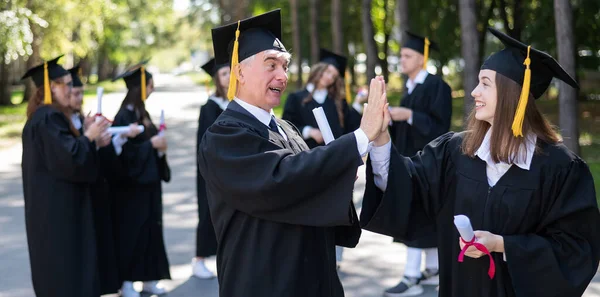 Group Graduates Robes Outdoors Elderly Man Young Woman Congratulate Each — Stock Photo, Image