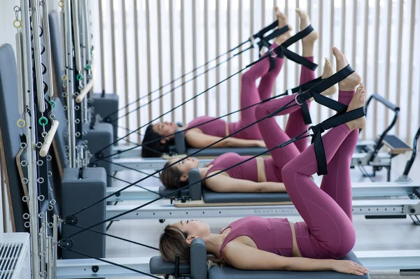 Pembe Spor Kıyafetli Asyalı Kadın Islah Yatağıyla Pilates Egzersizi Yapıyor — Stok fotoğraf