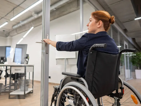 Rudowłosy Biały Kobieta Wózku Inwalidzkim Próbuje Otworzyć Drzwi Biurze — Zdjęcie stockowe