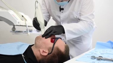 23.11.2021Rusya, Novosibirsk: Dişçi hastaların çenelerini tarıyor ve 3B model gösteriyor