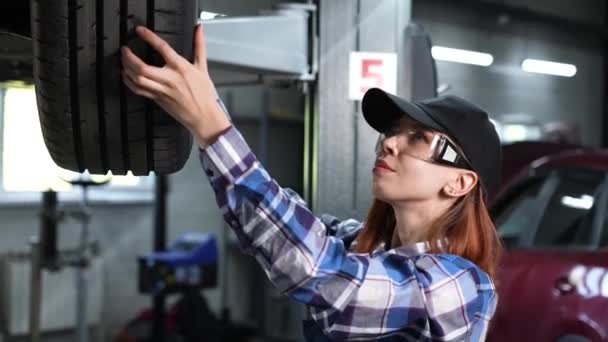Female Mechanic Adjusting Tire Car Lift Girl Mans Work — Stock Video