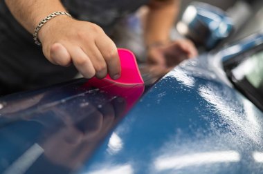 Araba servisindeki usta arabaya zırh filmi uyguluyor.