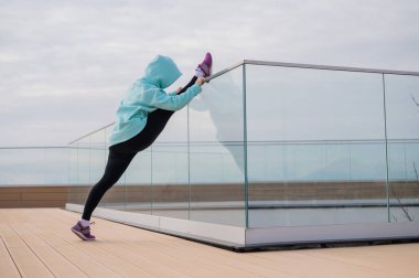 Tişörtlü beyaz bir kadın sicimin üzerinde esniyor.