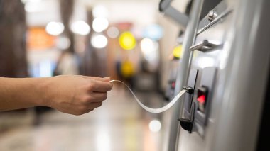 Bir kadın, self-servis bilet bürosundan tren bileti alır.