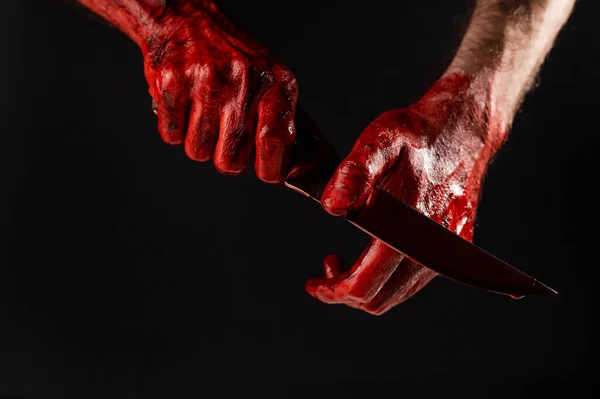 黒い背景に血のナイフを手で拭く男 — ストック写真