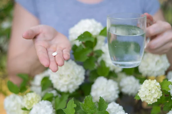 Çiçek Açan Bahçede Elinde Antihistamin Tableti Bir Bardak Tutan Bir — Stok fotoğraf