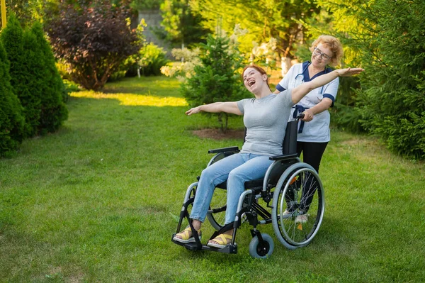 Elderly Nurse Walks Middle Aged Woman Wheelchair Park Girl Spread — Stockfoto