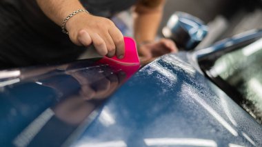 Araba servisindeki usta arabaya zırh filmi uyguluyor.