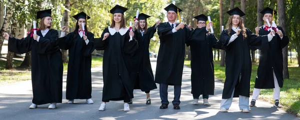 Group Graduates Robes Dancing Outdoors Elderly Student — стоковое фото