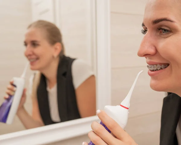 Kobieta Aparatem Zębach Używa Nawadniacza Portret Bliska — Zdjęcie stockowe