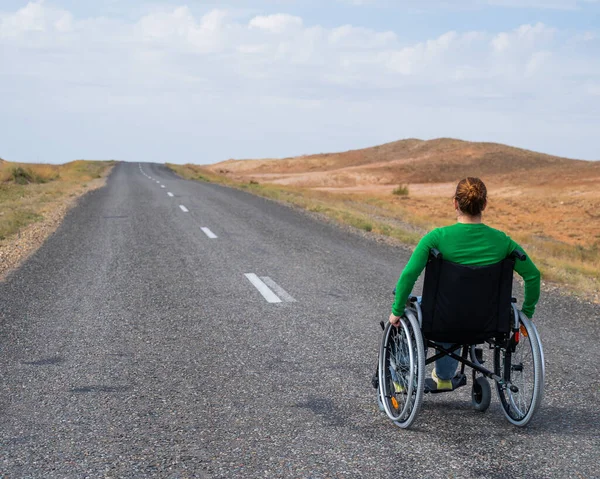 Bozkırlarda Otoyolda Tekerlekli Sandalyedeki Kadın — Stok fotoğraf