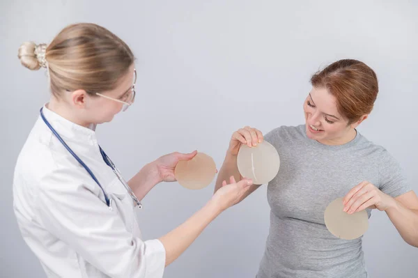 Biała Kobieta Przymierza Implanty Piersi Chirurg Plastyczny Pomaga Pacjentowi Wyborem — Zdjęcie stockowe