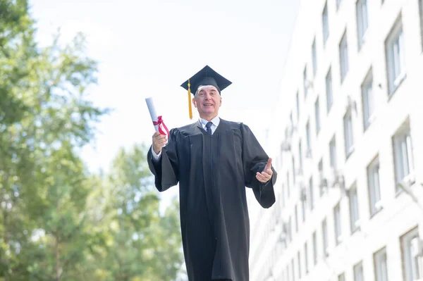 Old Man Graduation Gown Walks Outdoors Holds Diploma — Photo