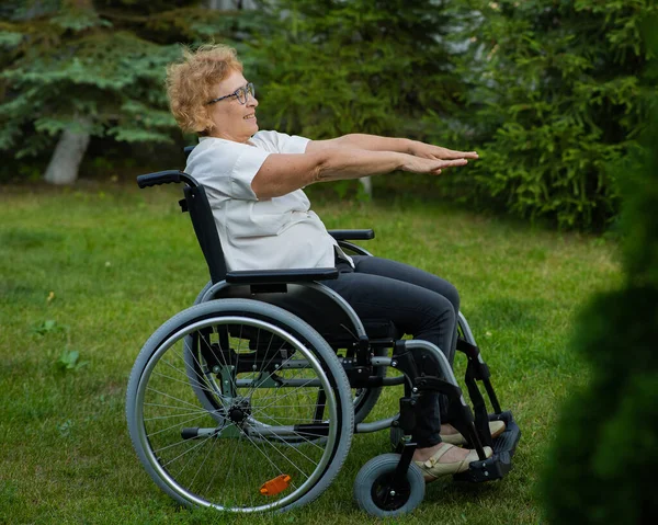 Пожилая Белая Женщина Делает Упражнения Сидя Инвалидной Коляске Открытом Воздухе — стоковое фото