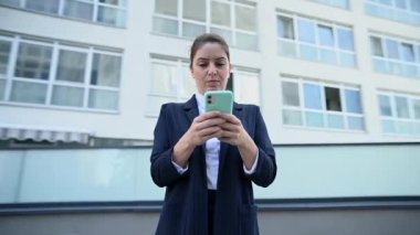 Video 360 derece. Kafkasyalı iş kadını dışarıda akıllı telefondan mesaj yazıyor.