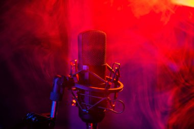 Siyah arka planda kırmızı mavi dumanlı profesyonel mikrofon.