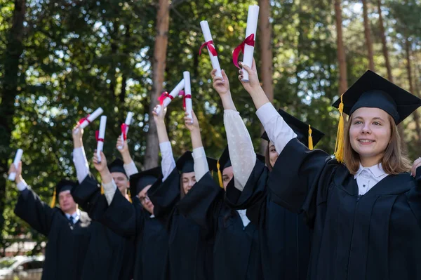 Group Graduates Robes Raised Hands Diplomas Outdoors Elderly Student — Zdjęcie stockowe
