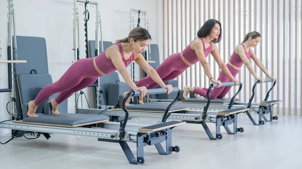 Three Asian Women Doing Plank Reformer Machine — Stok fotoğraf