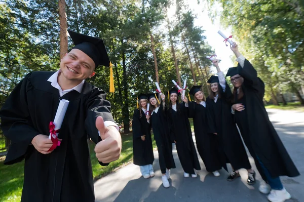 Šťastný Mladý Běloch Ukazuje Palce Nahoru Skupina Postgraduálních Studentů Venku — Stock fotografie