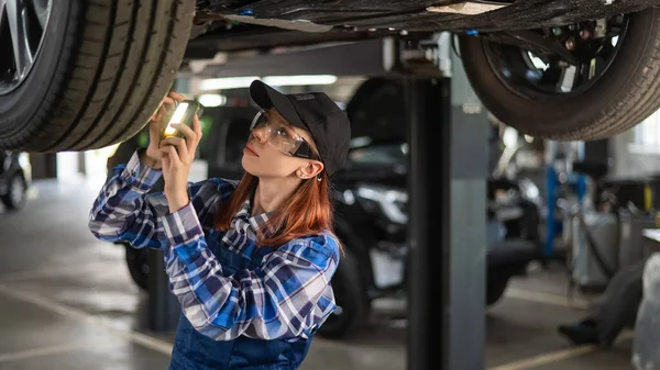 Kobieta Mechanik Sprawdza Podnoszony Samochód Dziewczyna Pracy Dla Mężczyzn — Zdjęcie stockowe