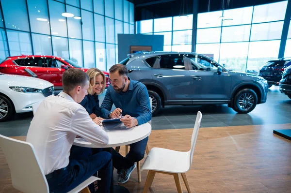 Szczęśliwa Kaukaska Para Podpisuje Kontrakt Zakup Salonu Samochodowego — Zdjęcie stockowe