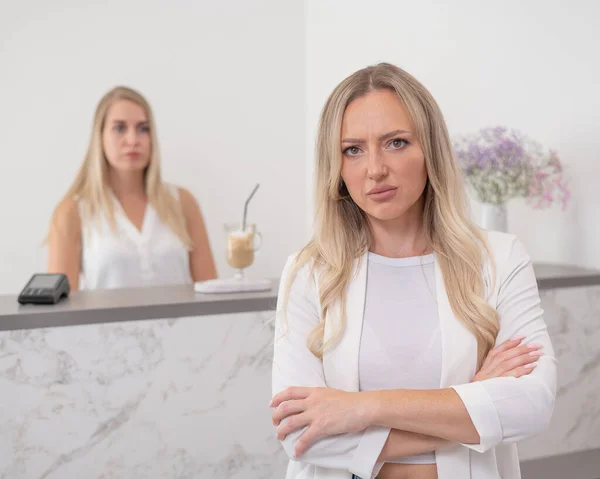 Dissatisfied client stands at the reception of a beauty salon