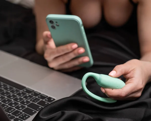 여자가 침대에 스마트폰으로 기계를 동기화 합니다 노트북에서 비디오를 — 스톡 사진