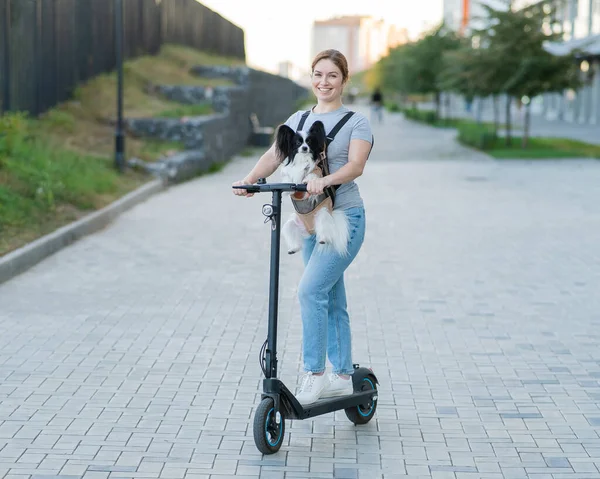 Uma Mulher Monta Uma Scooter Elétrica Com Cão Uma Mochila — Fotografia de Stock