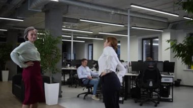 Four office workers warm up during a break. Employees do fitness exercises at the workplace. Slow motion